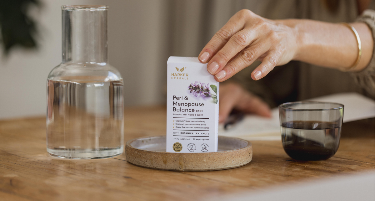 lifestyle image of eri & menopause daily dose product. Women reaching for product with glass water 